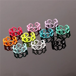 Detail showing colorful heart-shaped hollow rings set with vibrant matte lacquer finish