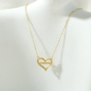 Detail van gouden hart hanger met mamma gravure en fonkelende zirkonia op een fijne ketting