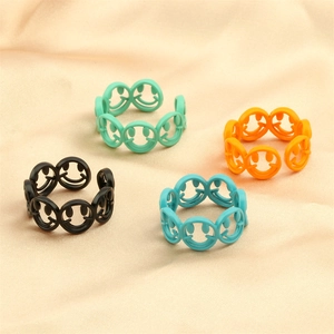 Detailed view of colorful smiling face cutout open rings in multiple matte finishes