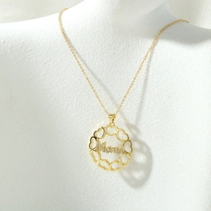 Detailweergave van gouden MOM-ketting met hartvormige hanger op model voor Moederdagcadeau