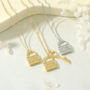 Dettaglio macro dei ciondoli a lucchetto e chiave LOVE placcati in oro 18K e argento