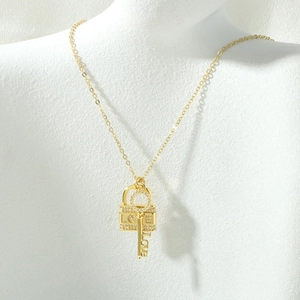 Dettaglio della collana placcata oro 18K con ciondoli lucchetto LOVE e chiave sul collo