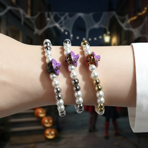 Three-piece Halloween bracelet set with pumpkin charms and witch hat on elastic beads