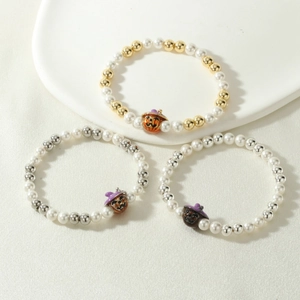 Detailed view of Halloween beaded bracelets with pumpkin charm and elastic cords