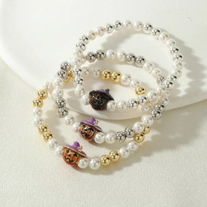 Detail of Halloween beaded bracelet set featuring white pearls and enamel pumpkin charm