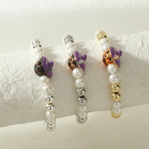 Macro detail of Halloween elastic bracelets with witch hat pumpkins and faux pearls