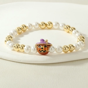 Close-up of Halloween beaded bracelet with orange pumpkin charm and purple wizard hat
