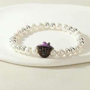 Detail of Halloween beaded bracelet with white pearls and a pumpkin wizard charm