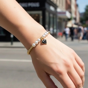 Pulsera de cuentas doradas con perlas blancas y colgante de diamante en la muñeca