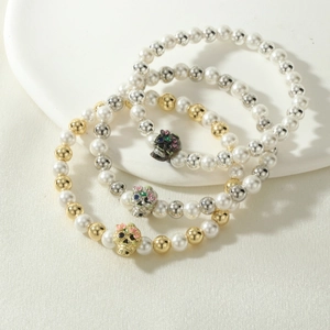 Detailed view of three-piece beaded bracelets featuring colored skull pendants on a tray