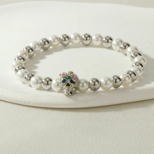 Close-up of beaded Halloween bracelet with skull charm and colorful enamel details