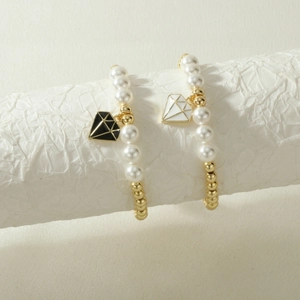 Detalle de pulseras de cuentas con perlas blancas y colgantes esmaltados de diamante