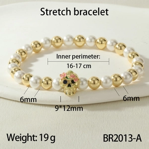 Detailed macro view of beaded stretch bracelet with skull charm and floral accents
