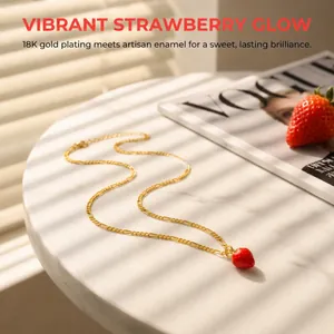 Macro shot of 18K gold plated strawberry pendant necklace on white marble with shadows