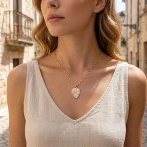 Elegant gold leaf pendant necklace with colorful enamel inlay on a model