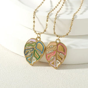 Gold leaf necklace with colorful enamel and diamonds on white geometric display stand