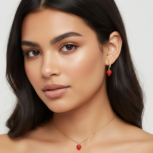 Detail shot of strawberry pendant necklace and stud earrings set with red enamel finish