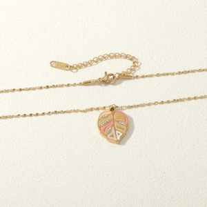 Macro shot of K14 gold leaf pendant with pink enamel inlay and sparkling crystals