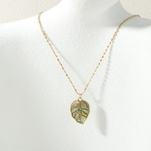 Detail of colorful leaf pendant necklace with zircon accents on a neck model