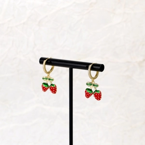 Detail of red strawberry drop earrings with gold metal and sparkling zircon stones