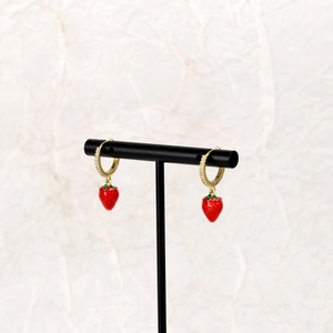 Close-up of strawberry drop earrings with sparkling rhinestones on gold hoops