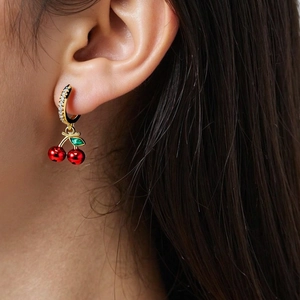 Detail of cherry hoop earrings featuring red fruit and green leaves with inlaid zircon stones