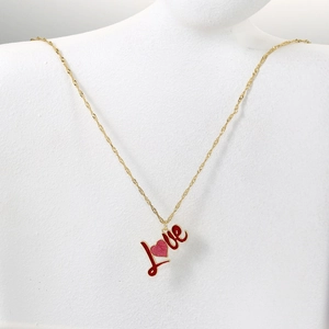 Detail der 18K vergoldeten Love-Herz-Halskette mit roter Emaille auf einer weißen Büste