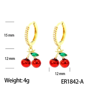 Detailed view of red cherry earrings with gold diamond-set hoops and green zircon leaf