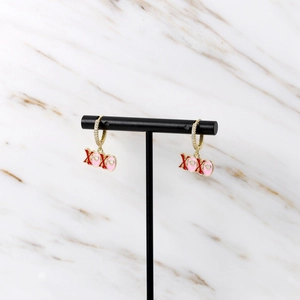 Detail der XOXO Herz-Ohrringe mit roter Emaille und Kristallen auf Goldbasis