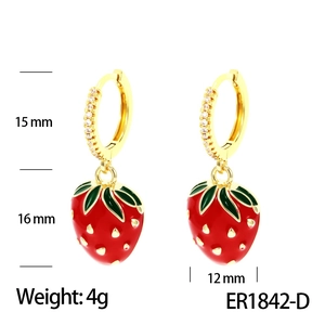 Detail view of gold hoop earrings with red strawberry charms and zircon accents