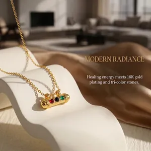 Detail of 18K gold plated necklace with capsule pendant and colorful gemstones