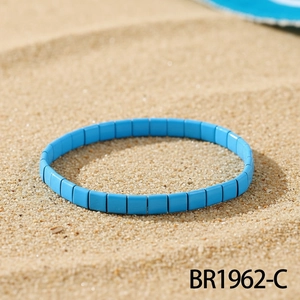 Makroaufnahme von blauem TILA-Perlenarmband auf Sand mit böhmischen Emaille-Details