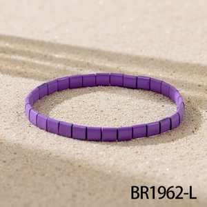 Detail eines lila matt Tila-Perlenarmbands auf Sand mit kunstvollen Blatt-Schatten