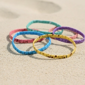 Bohemian colorful Tila bead stretch bracelets set on beach sand for summer vacation