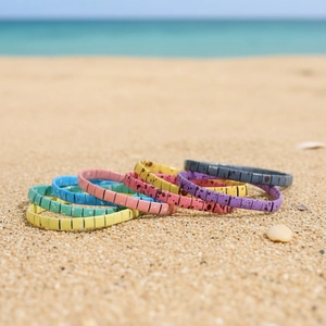 Bohemian Tila bead stretch bracelets in vibrant colors shown on a beach background