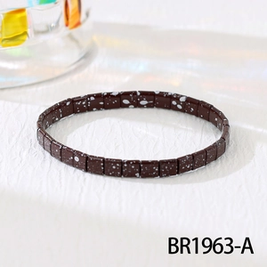 Detailed view of dark brown Tila bead stretch bracelet with white splatter pattern