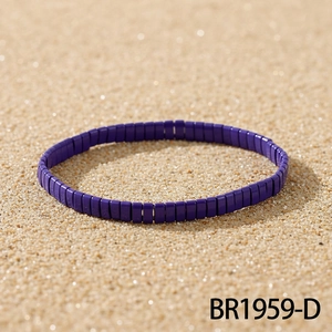 Detail shot of purple bohemian tila bead bracelet on beach sand for summer style