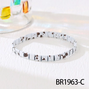 Macro shot of white Tila bead bracelet with dalmatian spots and elastic cord detail