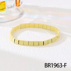 Detail shot of pale yellow TILA bead bracelet with white speckles on a white background