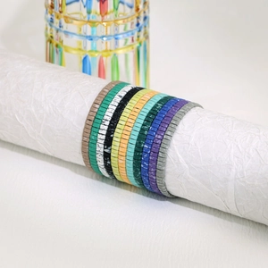 Gedetailleerd beeld van kleurrijke handgemaakte Tila kralenarmbanden set in bohemien stijl