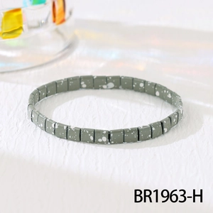 Close-up of grey-green Tila beads with white dots on a Bohemian stretch bracelet
