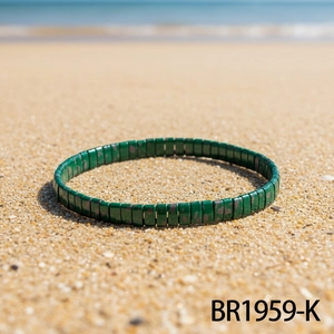 Green beaded bohemian elastic bracelet on a sandy beach for a vacation look