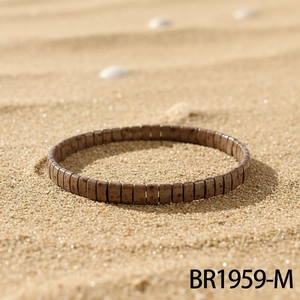Detail of beaded stretch bracelet on beach sand with natural bohemian vacation style