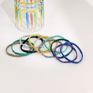 Detail van kleurrijke Boheemse Tila-kralenarmbanden in een tiendelige veelkleurige set