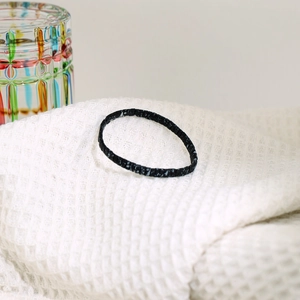 Detailweergave van de handgemaakte zwart-witte Tila kralenarmband op een witte stof