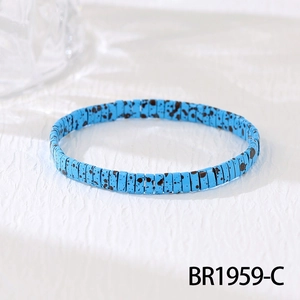 Close-up of bohemian blue Tila bead elastic bracelet with unique black speckled pattern