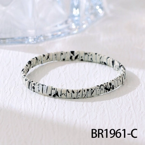 Detailopname van de Boheemse Tila-kralenarmband met crème en zwarte inktspatpatronen
