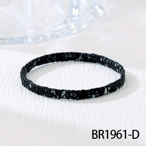 Detailopname van zwarte Tila-kralenarmband met grijs marmerpatroon op witte achtergrond