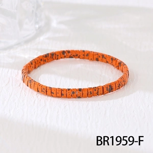 Detail shot of orange beaded bracelet with black leopard patterns in a bohemian style