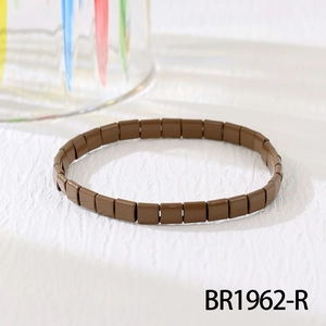 Nahaufnahme eines braunen Tila-Perlenarmbands mit glänzendem Finish auf hellem Grund